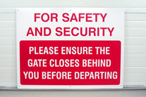 Gate closes behind, aluminum sign